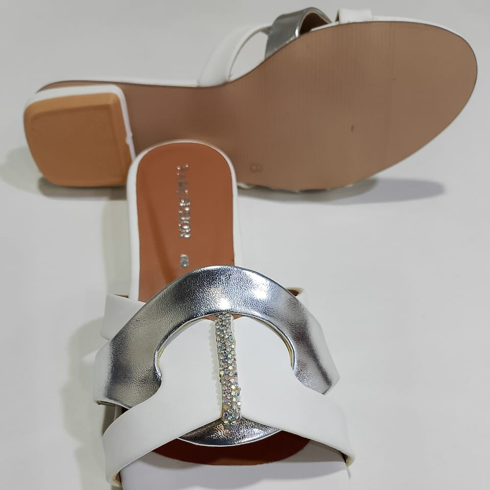 White sandal with a silver buckle on a white background