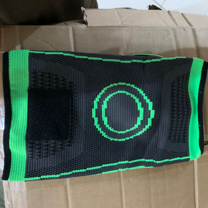 Black and green knee brace on a cardboard box