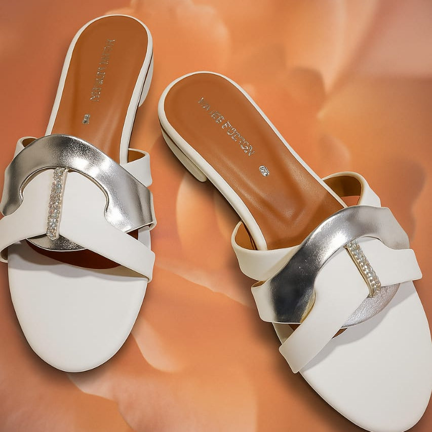 White sandals with silver straps on a floral background